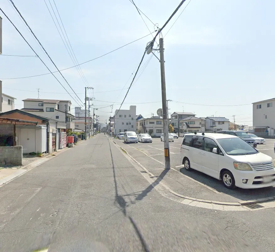 住宅街の道路に停車している車と駐車場